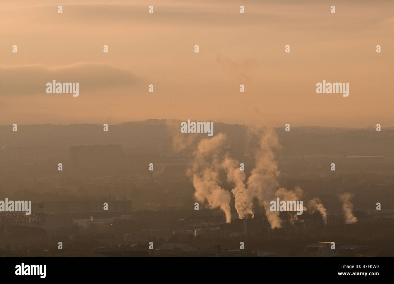 Vista di una fabbrica con fumi in uscita dei suoi camini. Foto Stock