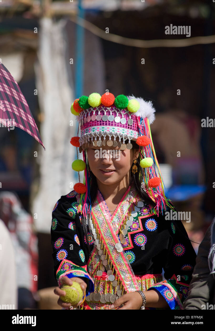 Una ragazza Hmong in costume tradizionale si ritiene che le catture di una sfera durante il Hmong Anno Nuovo cerimonia. Foto Stock