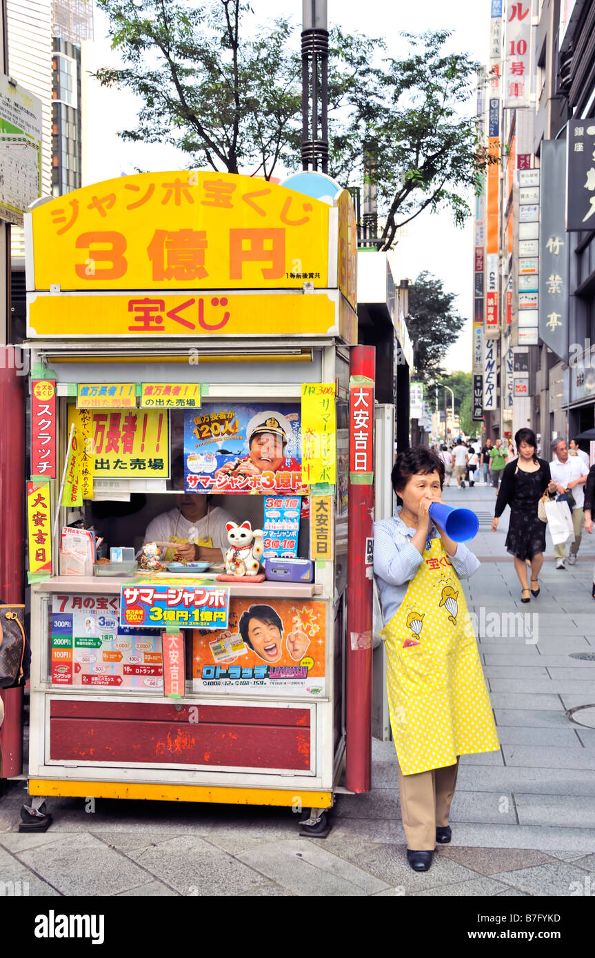 Donna Giapponese stand di pubbliche lotteria, Ginza, Giappone Foto Stock