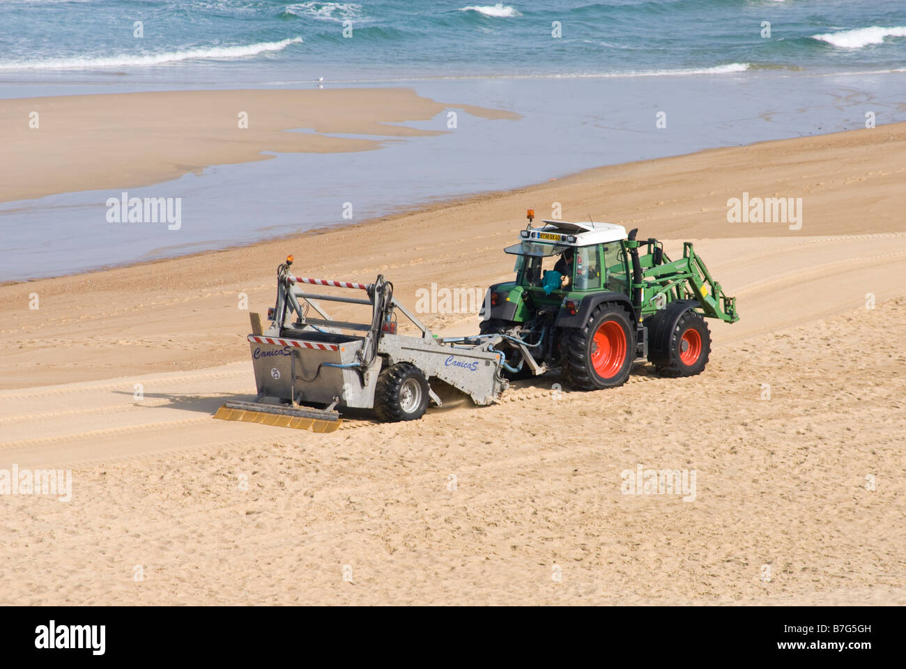 Il trattore azionato spiaggia macchina di pulizia. Foto Stock