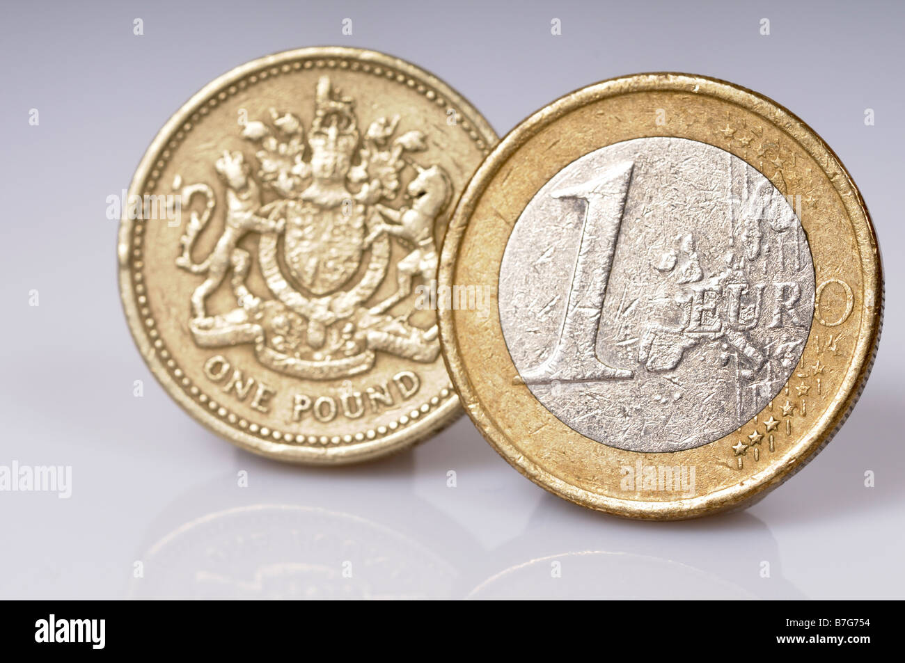 Foto di stock di un singolo Euro moneta accanto a una sola lira sterlina moneta sparato contro uno sfondo bianco Foto Stock
