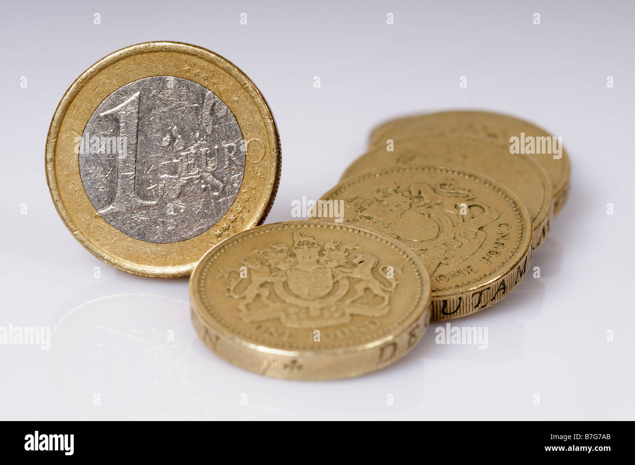 Foto di stock di un singolo Euro moneta accanto a una pila di lira sterlina monete Foto Stock