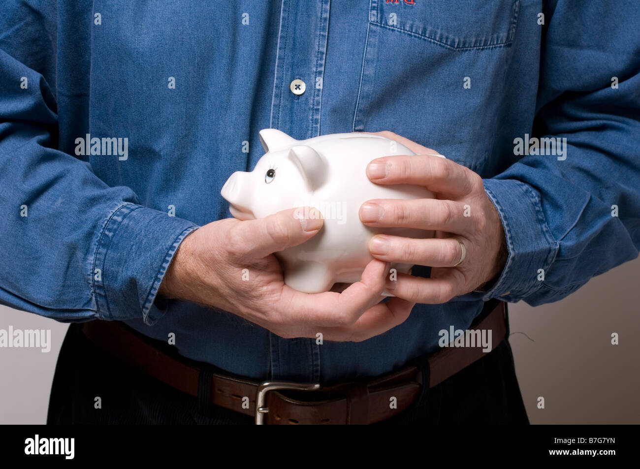 Un uomo che impugnano un prezioso salvadanaio Foto Stock