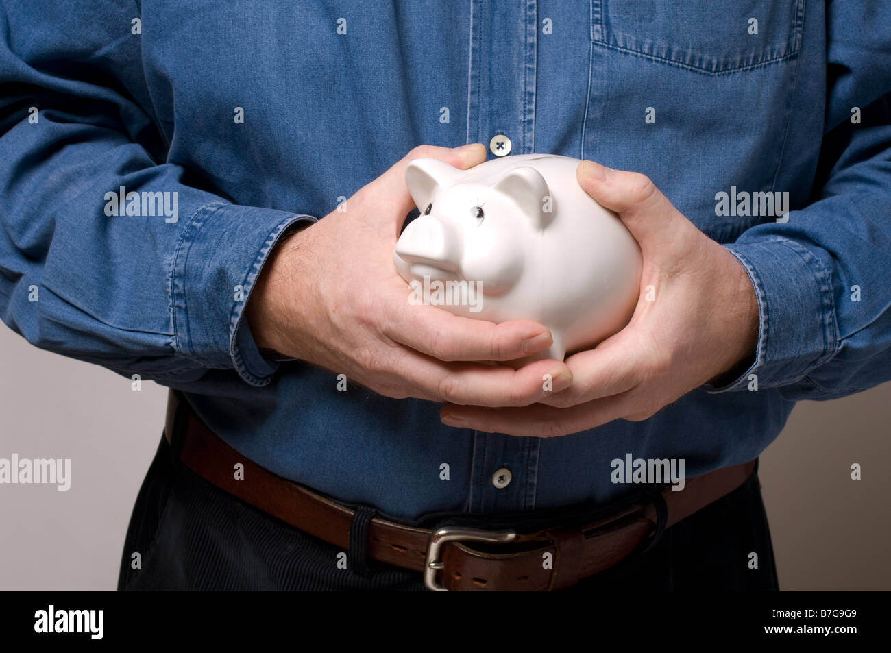 Un uomo che impugnano un prezioso salvadanaio Foto Stock