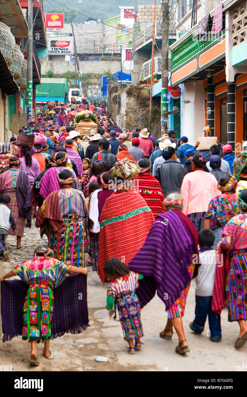 Una processione di indiani in Guatemala in abito tradizionale passeggiata attraverso le strade verso il cimitero di Zunil Guatemala Foto Stock