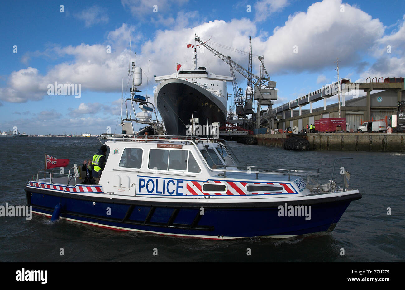 Barca di polizia di fronte alla QE2 Foto Stock