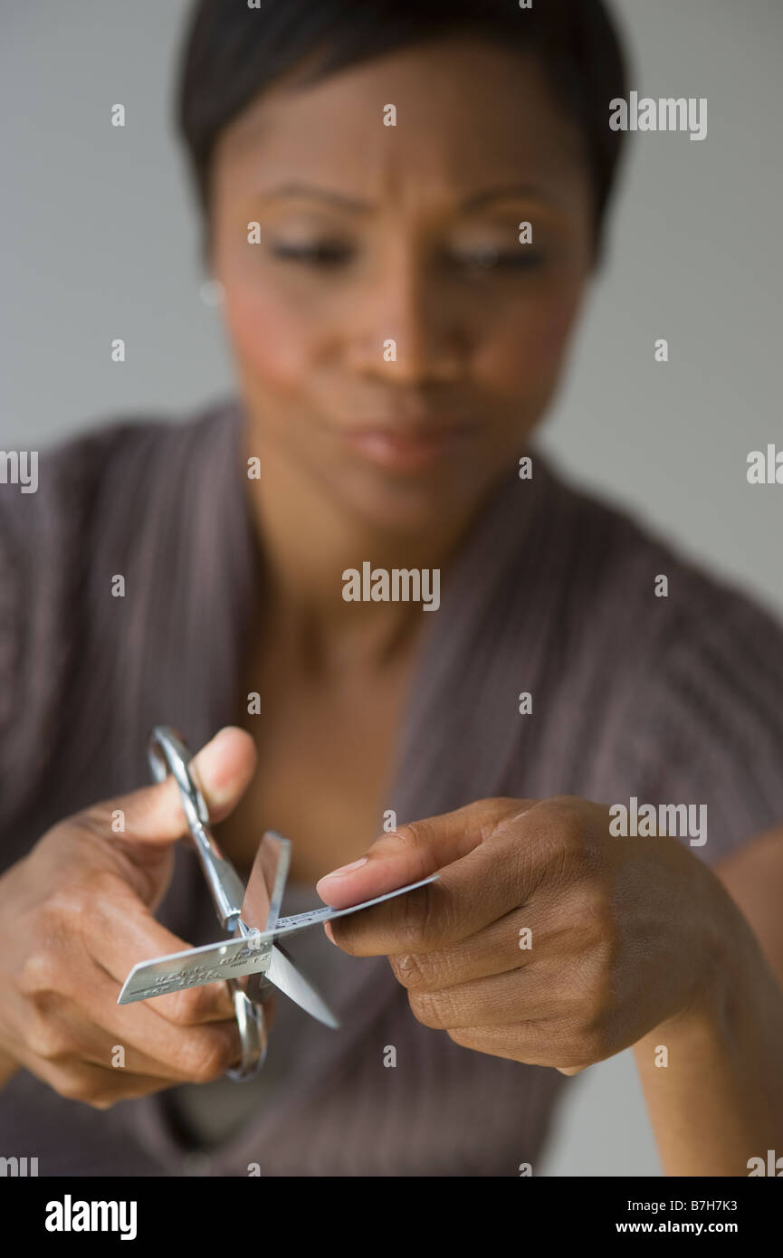 Frustrati donna africana il taglio di carta di credito Foto Stock
