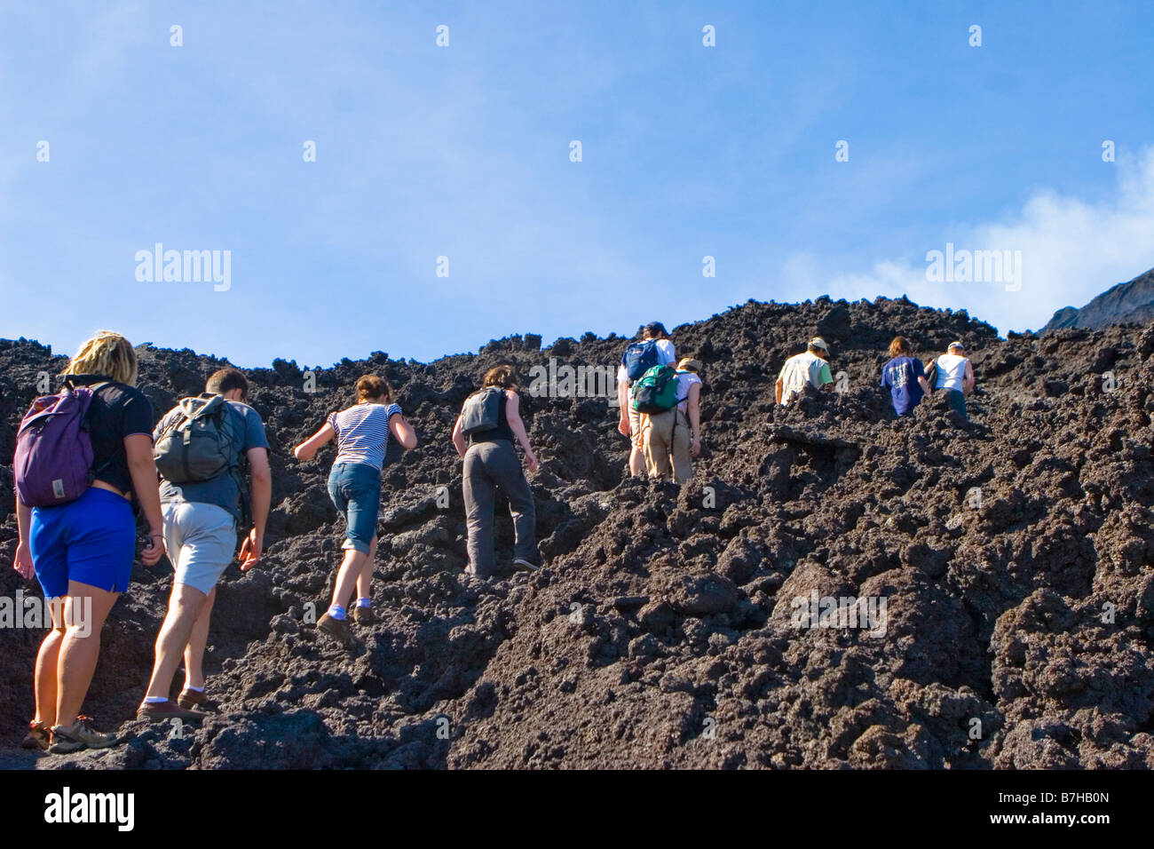 Gruppo di Tour salire il caldo torrido campi di lava di Volcan de Pacaya in Guatemala Foto Stock