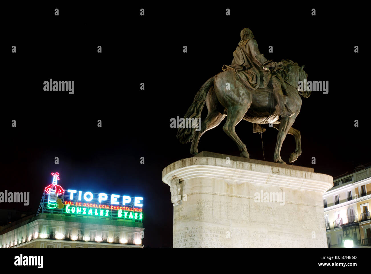 Tio Pepe insegna al neon e la statua equestre di re Carlos III. Vista notturna. Puerta del Sol. Madrid. Spagna. Foto Stock