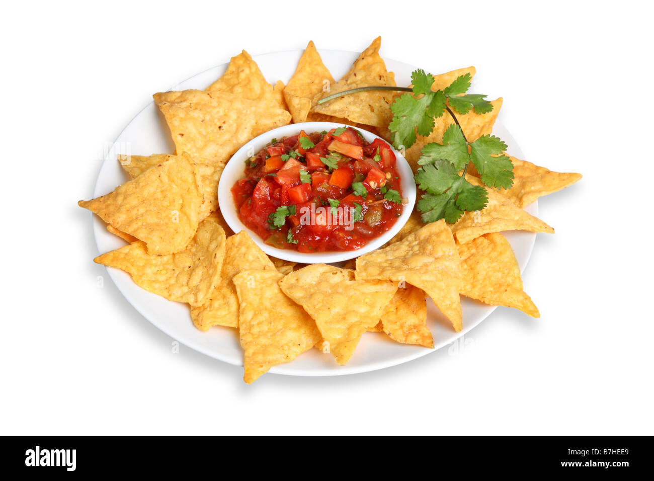 Piatto di tortilla chips e salsa ritagliata su sfondo bianco Foto Stock