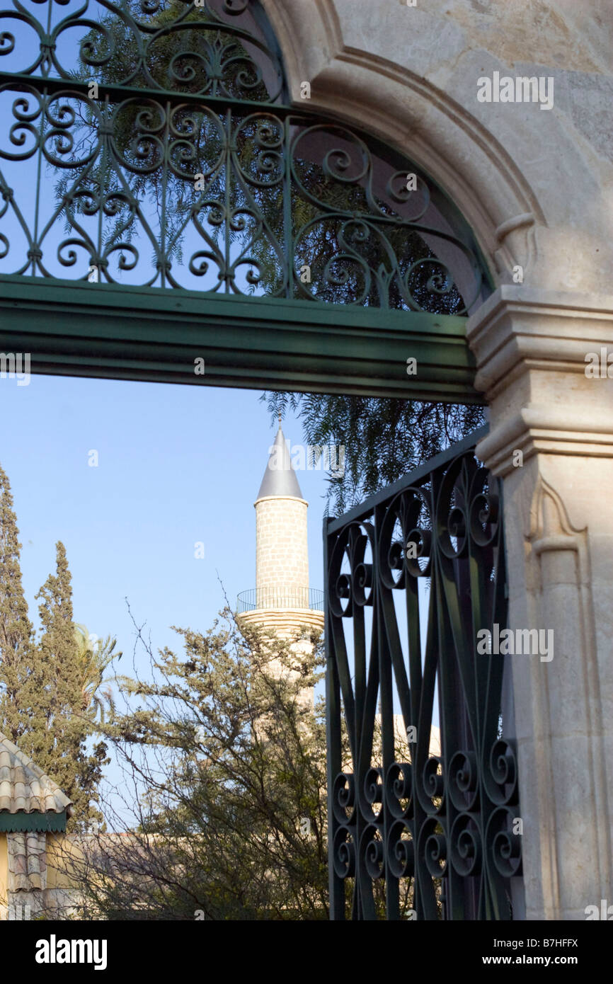 Vista attraverso Hala Sultan Tekkesi moschea cancello di ingresso nei pressi di Larnaca, Cipro sulla pietra gialla minareto. Foto Stock