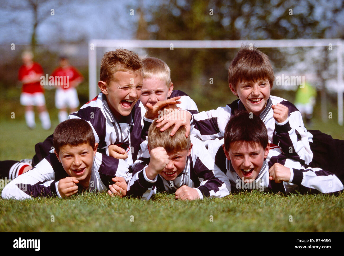 I bambini. Sport. Un gruppo di ragazzi felici celebrando la vittoria alla fine della partita di calcio. Foto Stock