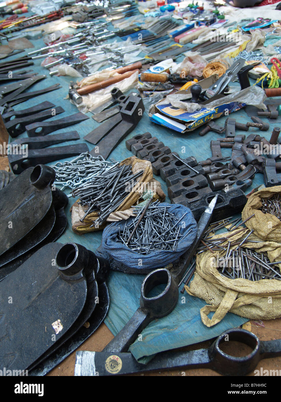Una fase di stallo in un Indiano mercato settimanale fornisce strumenti di ferro - zappe, picconi e teste di martello Foto Stock