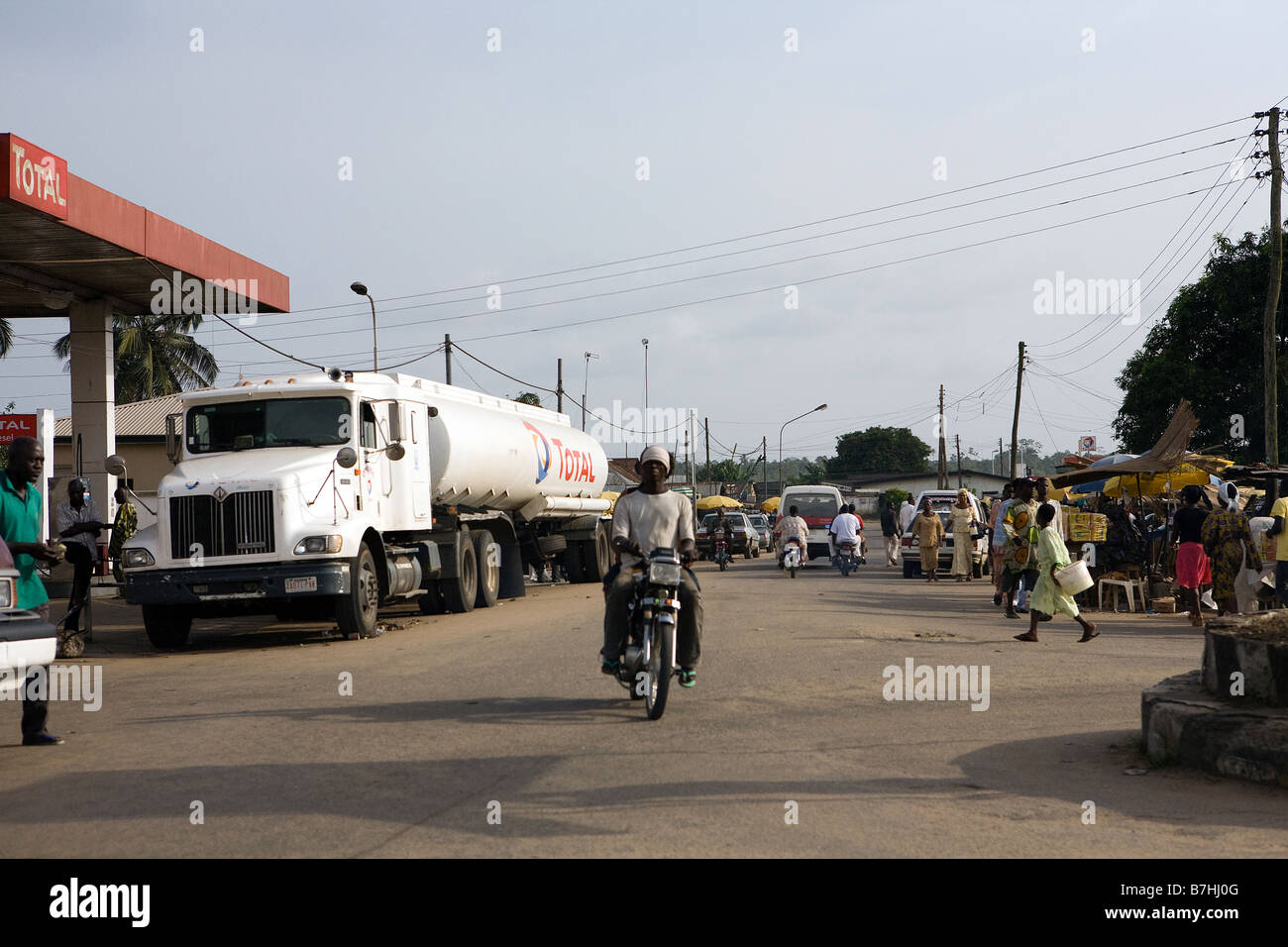 Un nigeriano corse maschio della sua moto attraverso la strada principale di Epe, Stato di Lagos, Africa Foto Stock