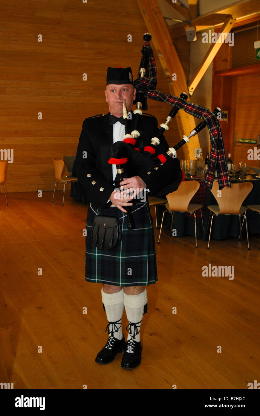 Un piper effettuando in corrispondenza di una bruciatura della notte cena Foto Stock