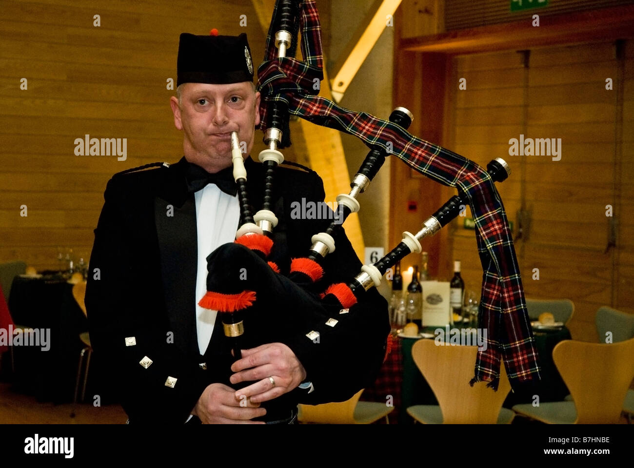 Un piper effettuando in corrispondenza di una bruciatura della notte cena Foto Stock