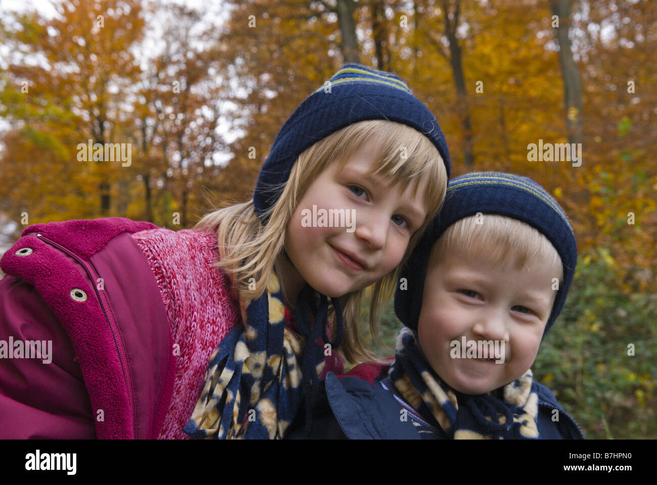 Piccolo Ragazzo e ragazza con tappi a una passeggiata in un bosco d'autunno, Francia, Lorraine Foto Stock