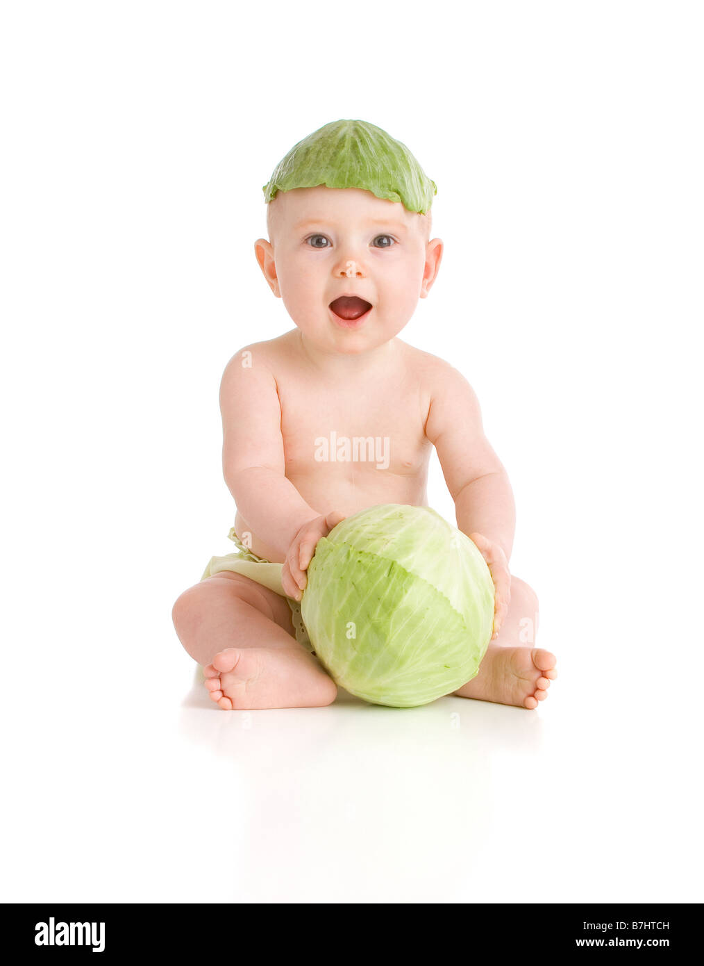Il bambino che indossa una foglia di cavolo hat tenendo un cavolo sul tasto alto sfondo bianco Foto Stock