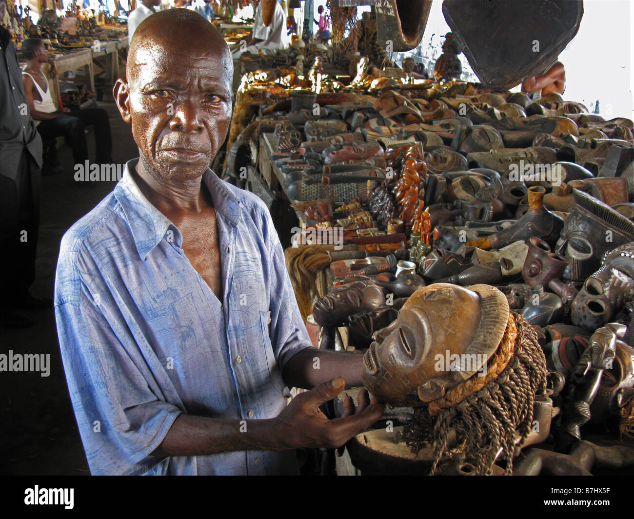 L'uomo africano congolesi di vendita maschere tradizionali nel vecchio mercato di antiquariato a Kinshasa nella Repubblica democratica del Congo Foto Stock