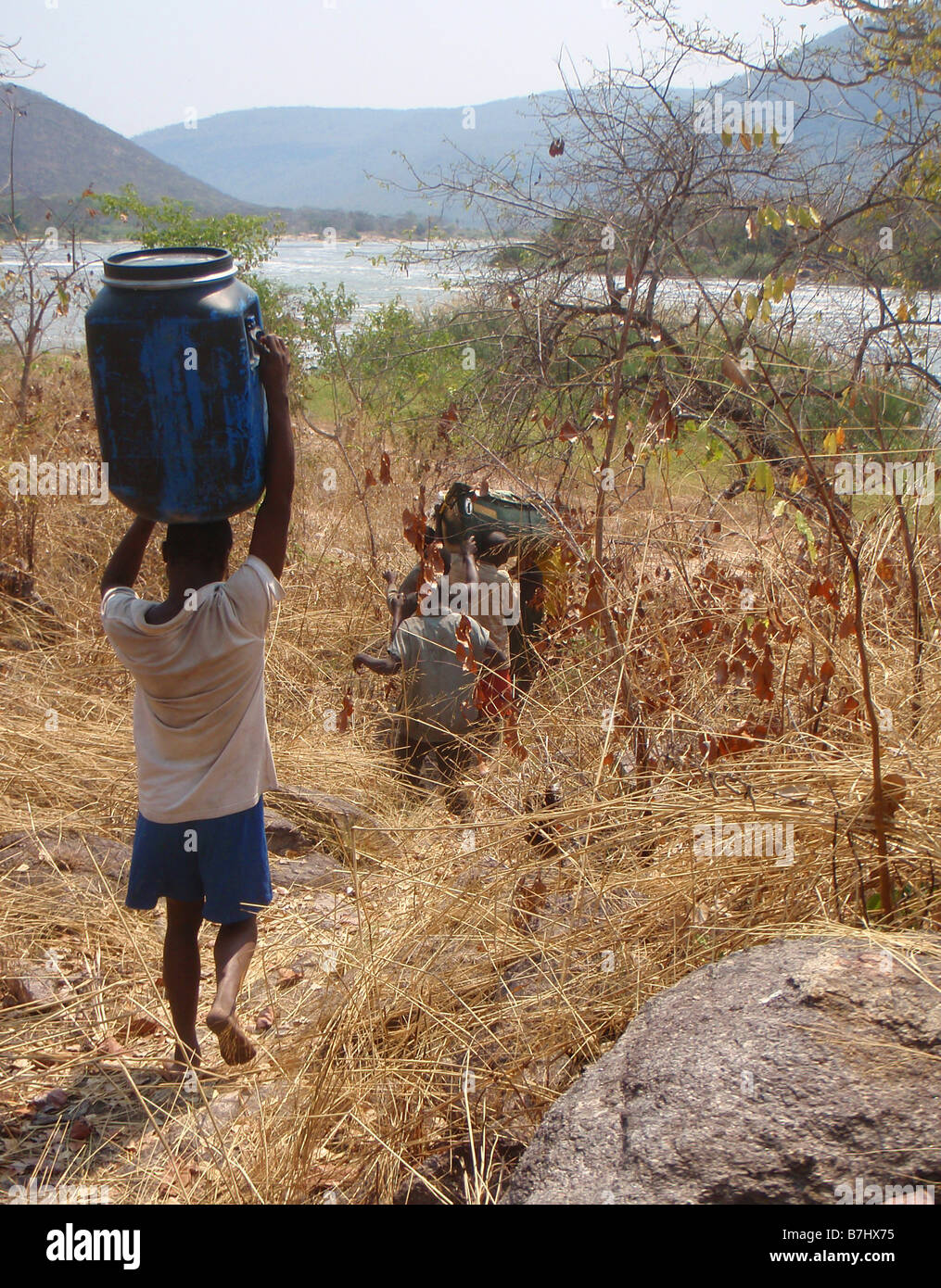 I pescatori locali portaging canoa e cibo canna intorno a rapide del fiume Luvua Repubblica Democratica del Congo Katanga provincia Foto Stock