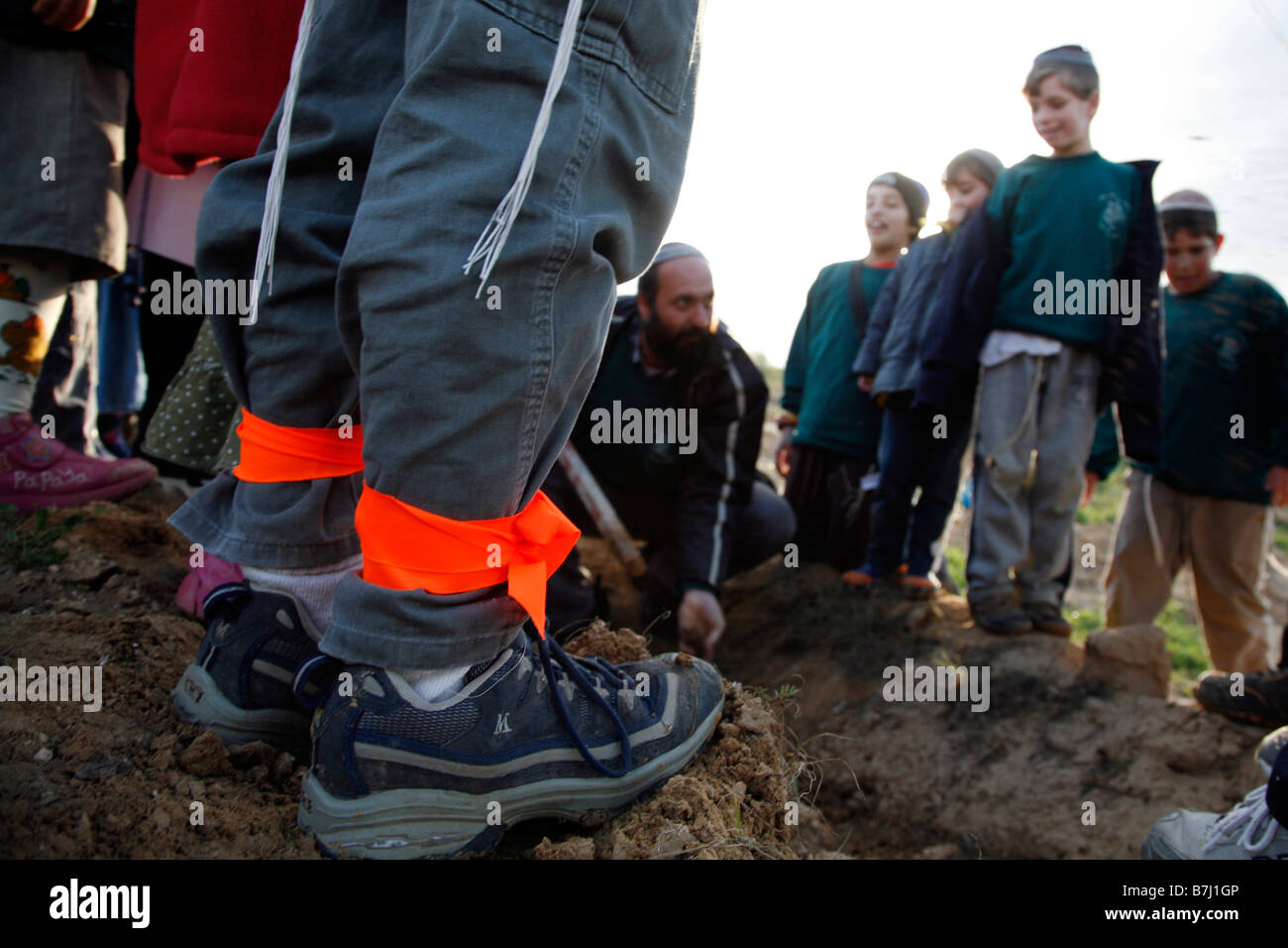 Nastri di colore arancione, simbolo dell'anti-movimento di disimpegno, legato intorno alle caviglie di un ragazzo israeliano. Foto Stock
