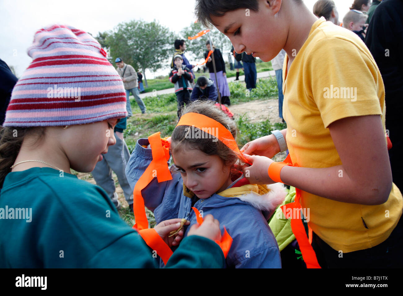 Un bambino israeliano di nastri di colore arancione, simbolo dell'anti-disimpegno, movimento legato ai suoi capelli. Foto Stock