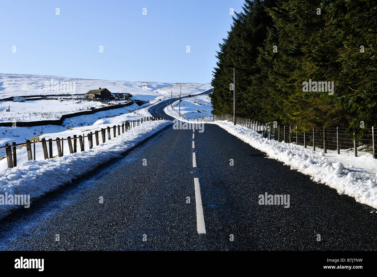 Lunga strada tortuosa nel paesaggio invernale Foto Stock