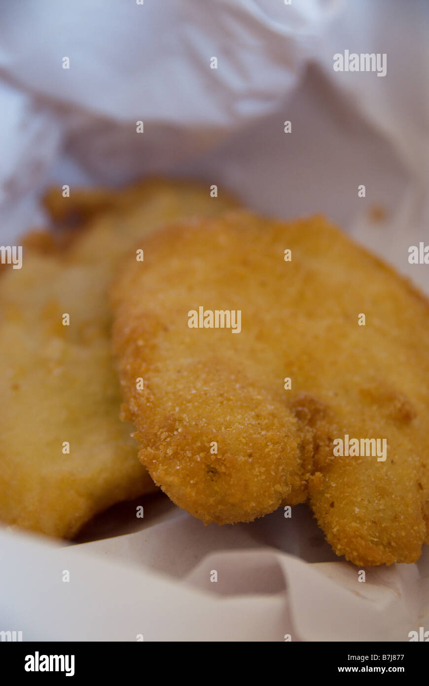 Australian pesce fritto avvolto in macelleria carta per estrarre lo sgombro qui è impanati scaglie e martoriata sotto di esso Foto Stock