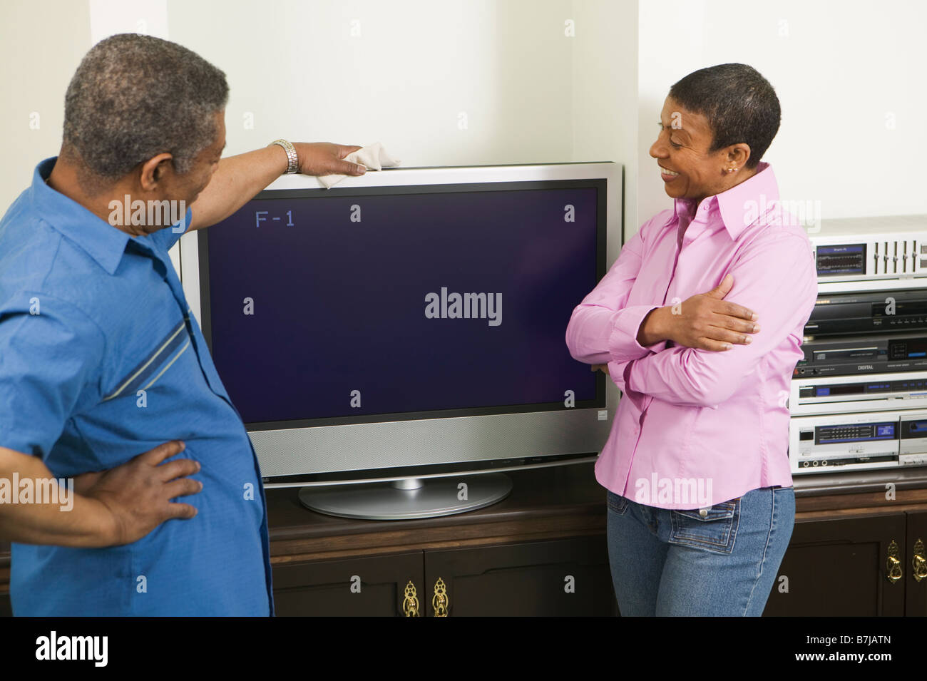 African American giovane installando una tv a schermo piatto, Vancouver, BC Foto Stock