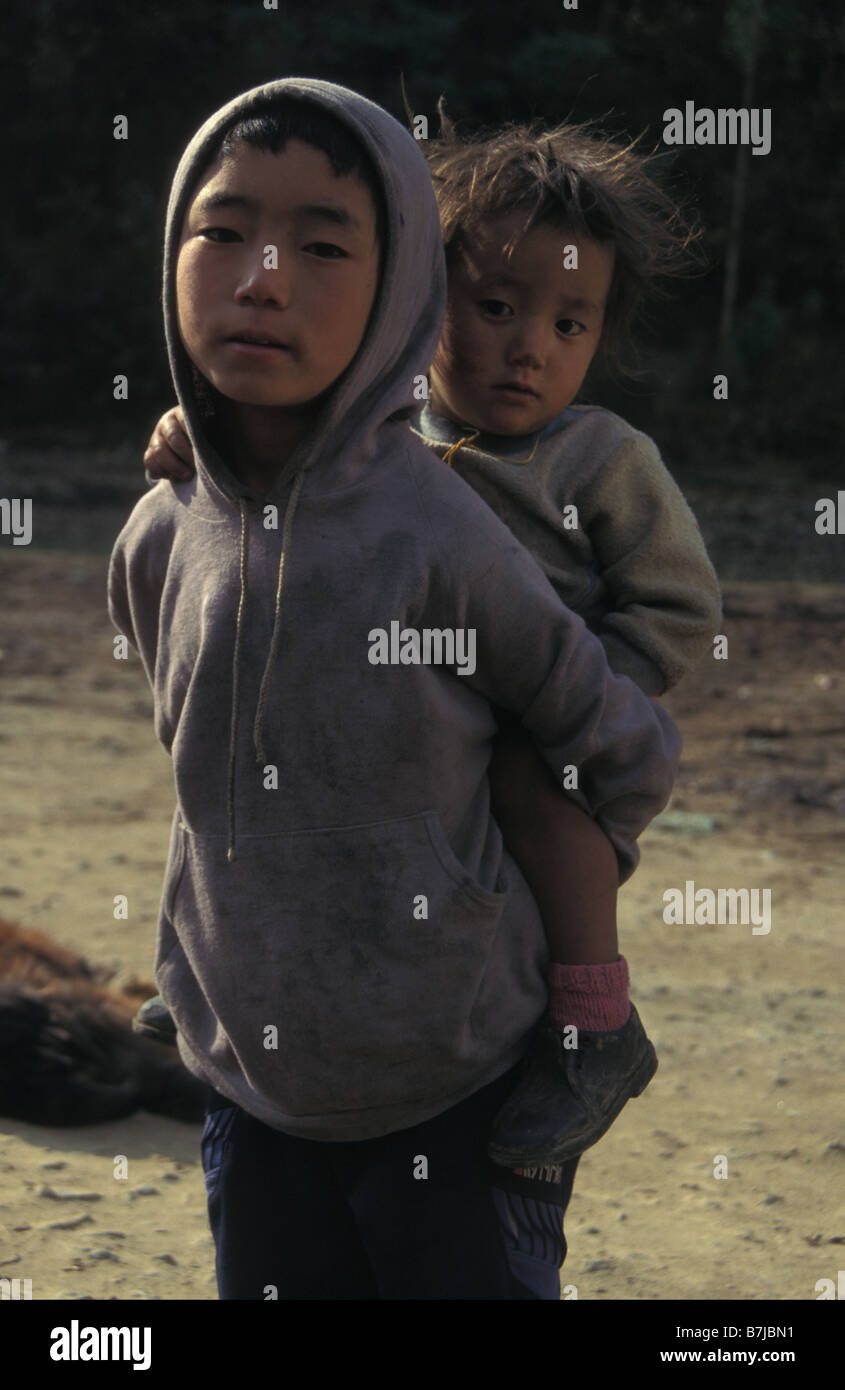 Ragazzo che trasportano bambino ortografia Sikkim India Foto Stock