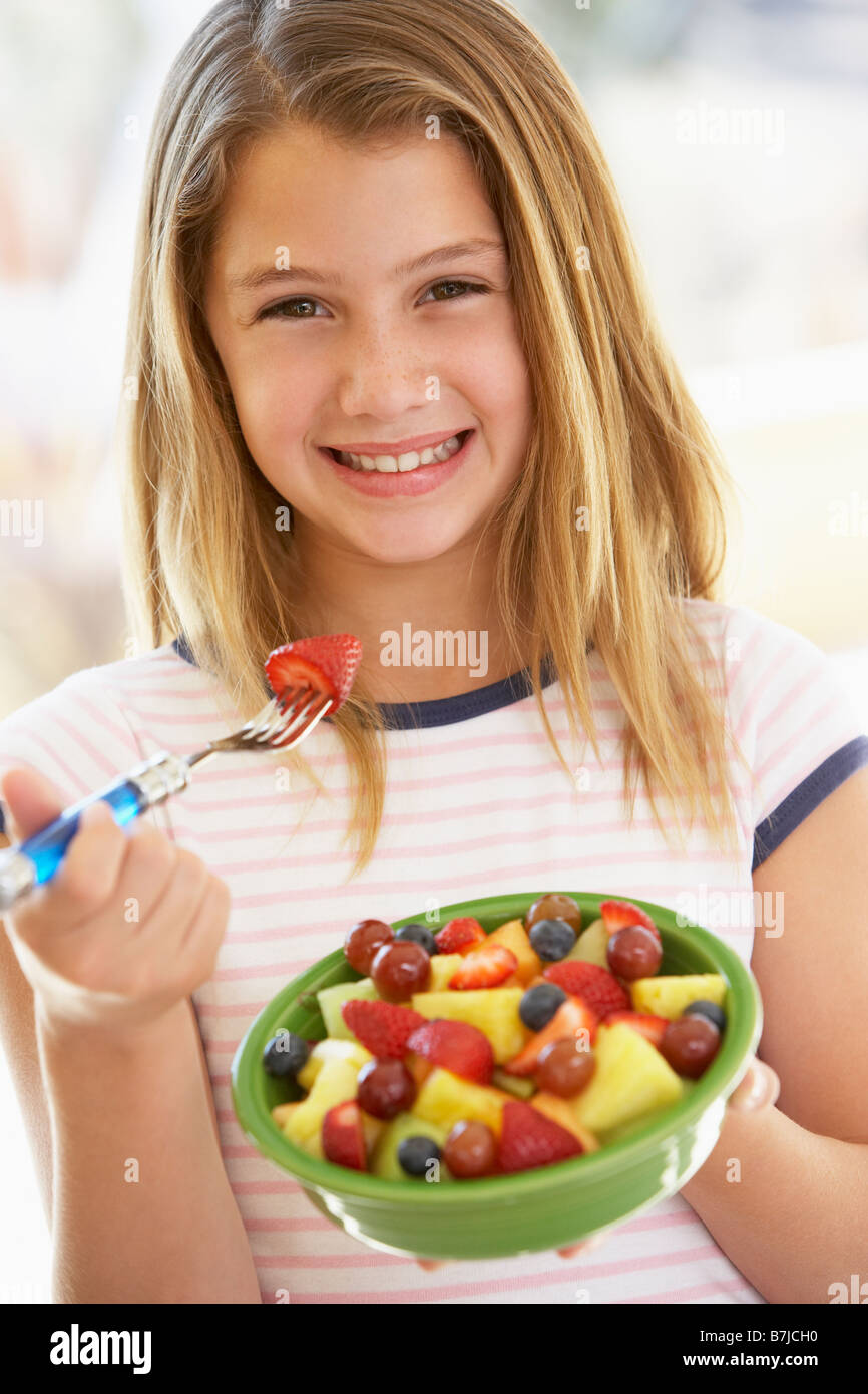 Ragazza giovane mangiare insalata di frutta fresca Foto Stock