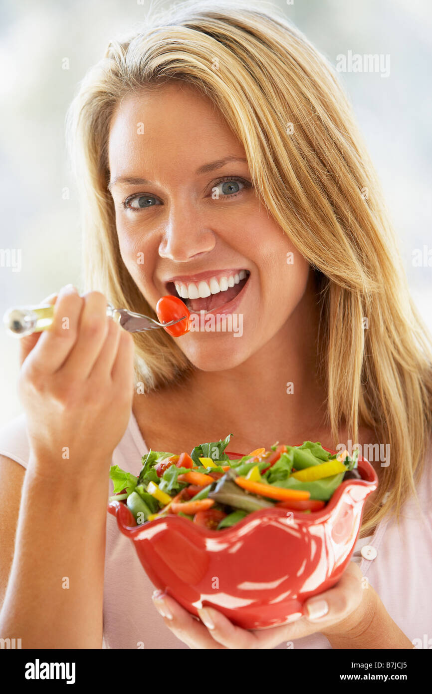 Giovane donna di mangiare insalata fresca Foto Stock