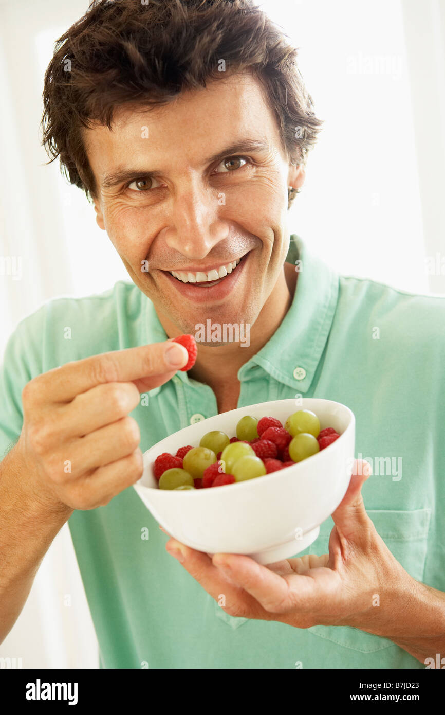 Metà uomo adulto mangiare frutta fresca Foto Stock
