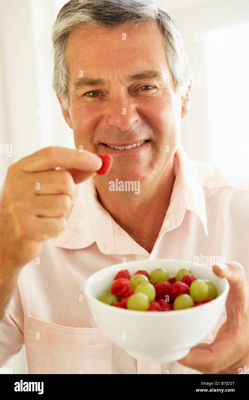 Uomo di mezza età di mangiare frutta fresca Foto Stock