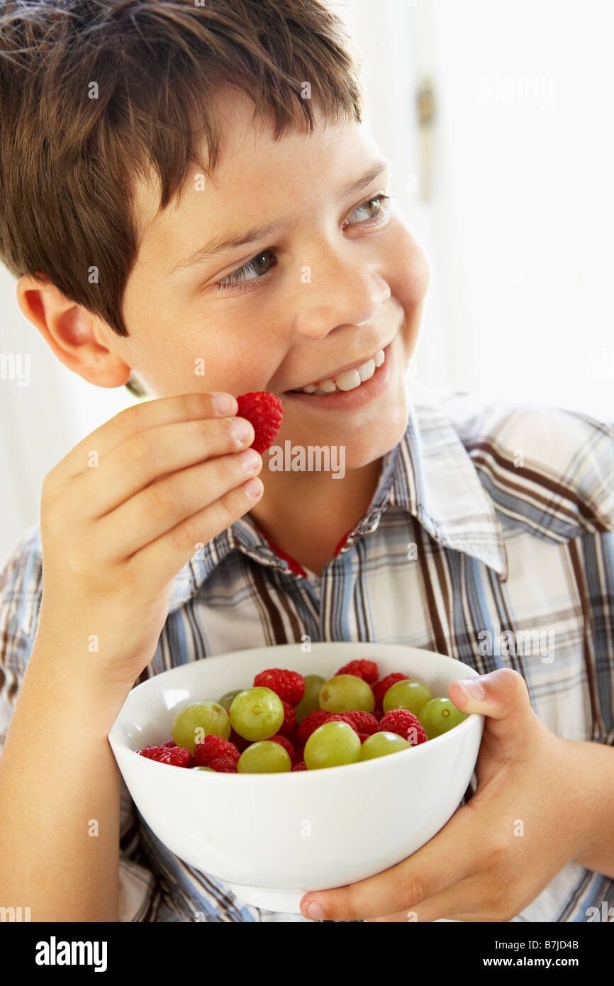 Ragazzo giovane mangiare frutta fresca Foto Stock