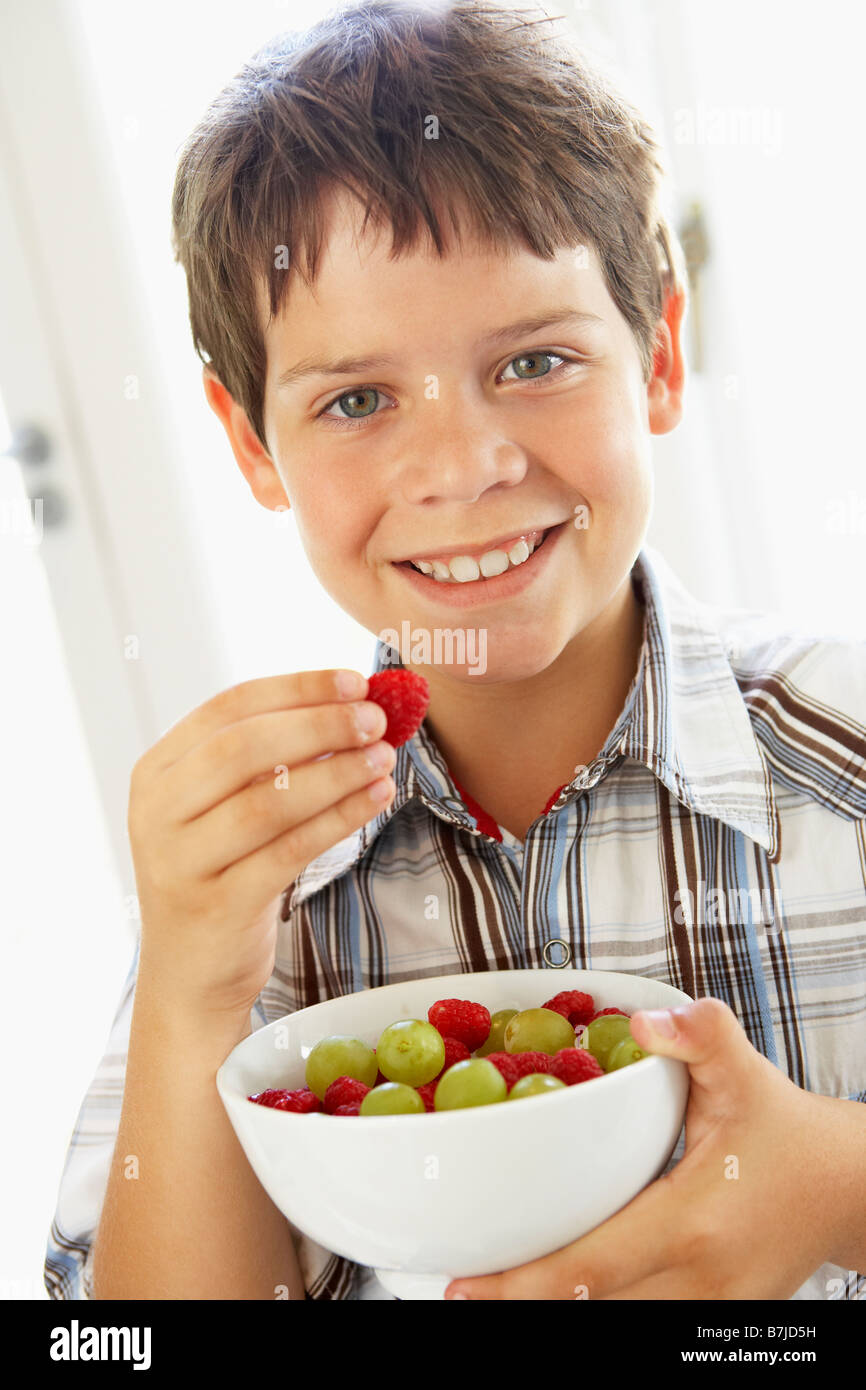 Ragazzo giovane mangiare frutta fresca Foto Stock