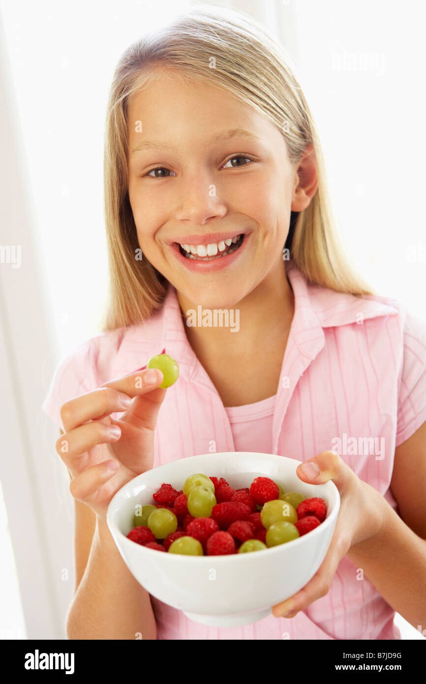 Ragazza giovane mangiare insalata di frutta fresca Foto Stock