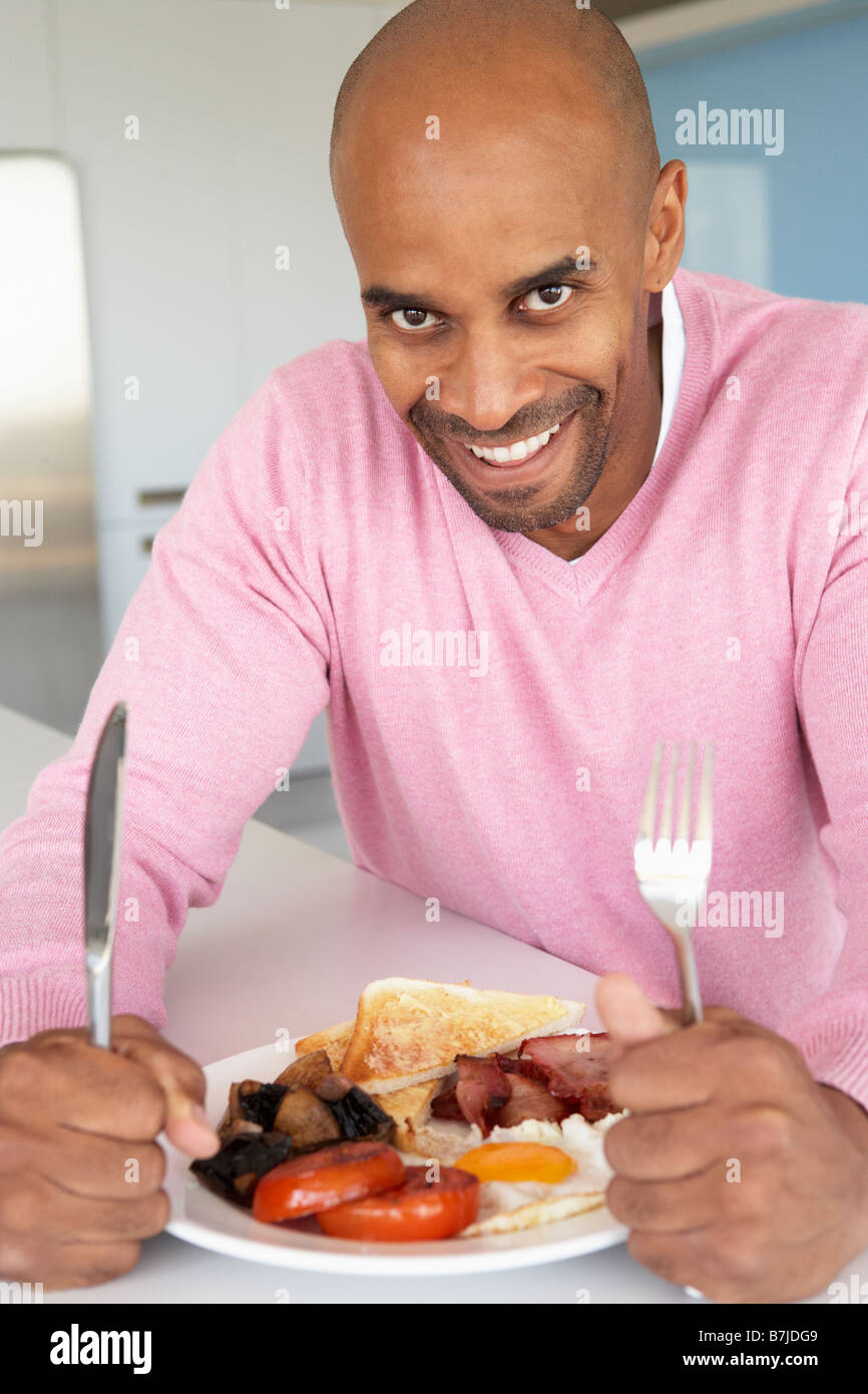 Uomo di mezza età mangiare malsano colazione fritta Foto Stock