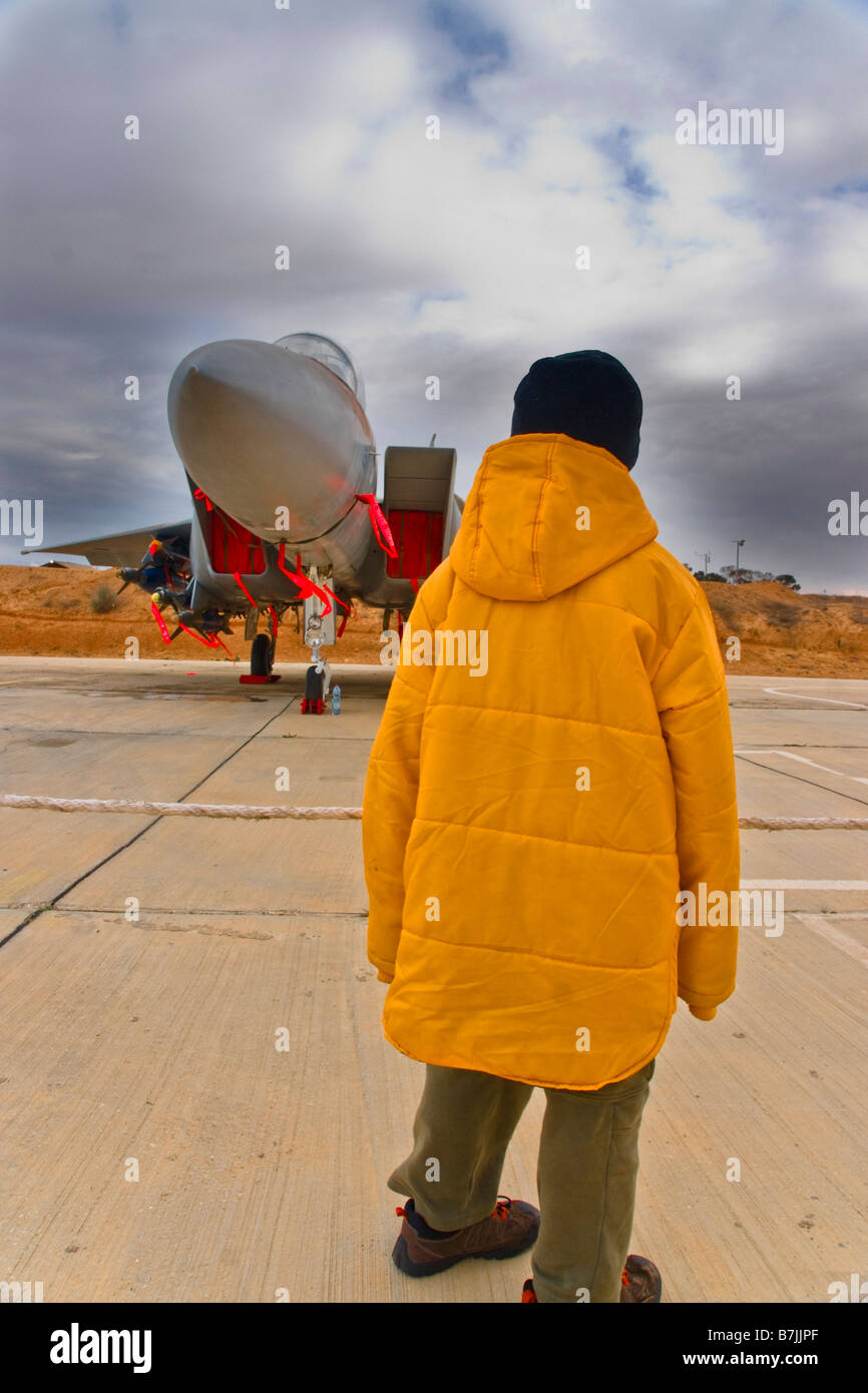 Hazerim, Israele. Un ragazzo guarda un'F-15 ("Raam') della forza aerea israeliana, IAF, in una fiera. Nuvole temporalesche. Foto Stock