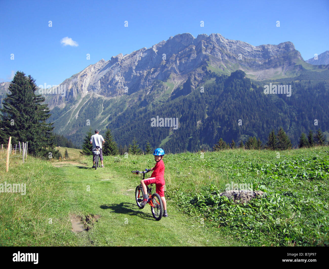 Una famiglia prendere un giro in bicicletta attraverso le Alpi svizzere durante le vacanze in Svizzera Foto Stock