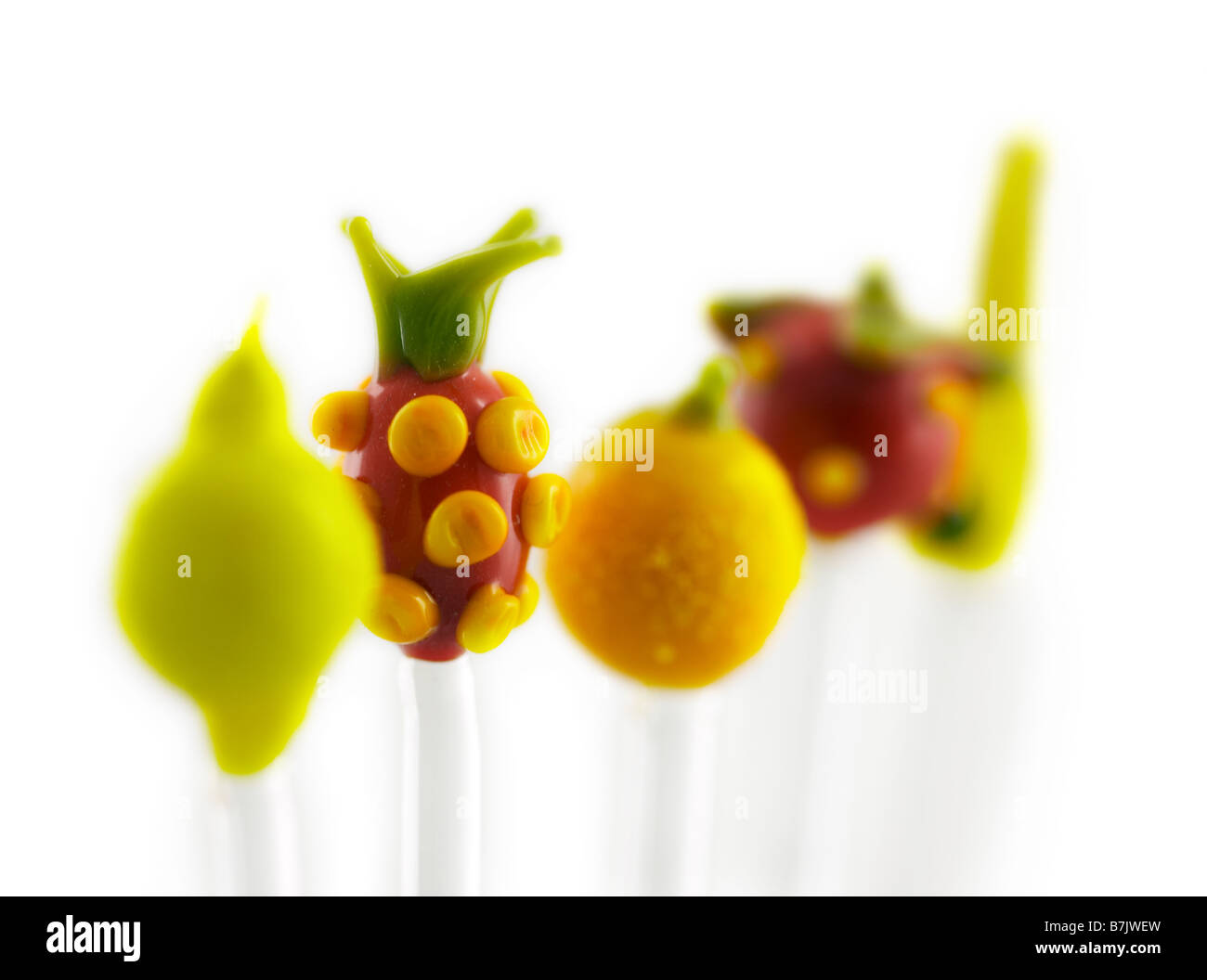 Fila di vetro colorati frutti isolati su sfondo bianco Foto Stock