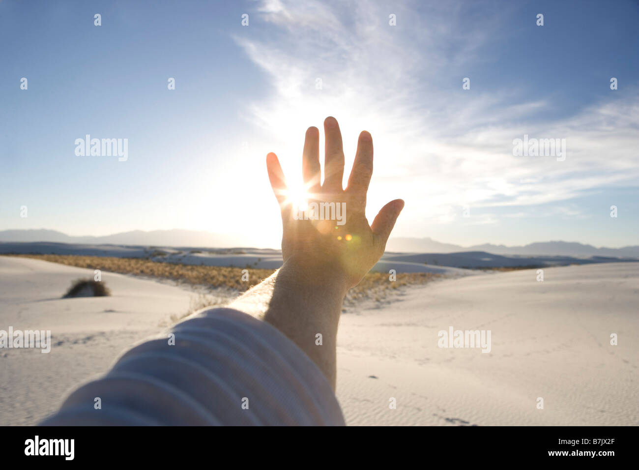 Lato essendo mantenuto fino al sole con cielo blu, le dune di sabbia Foto Stock