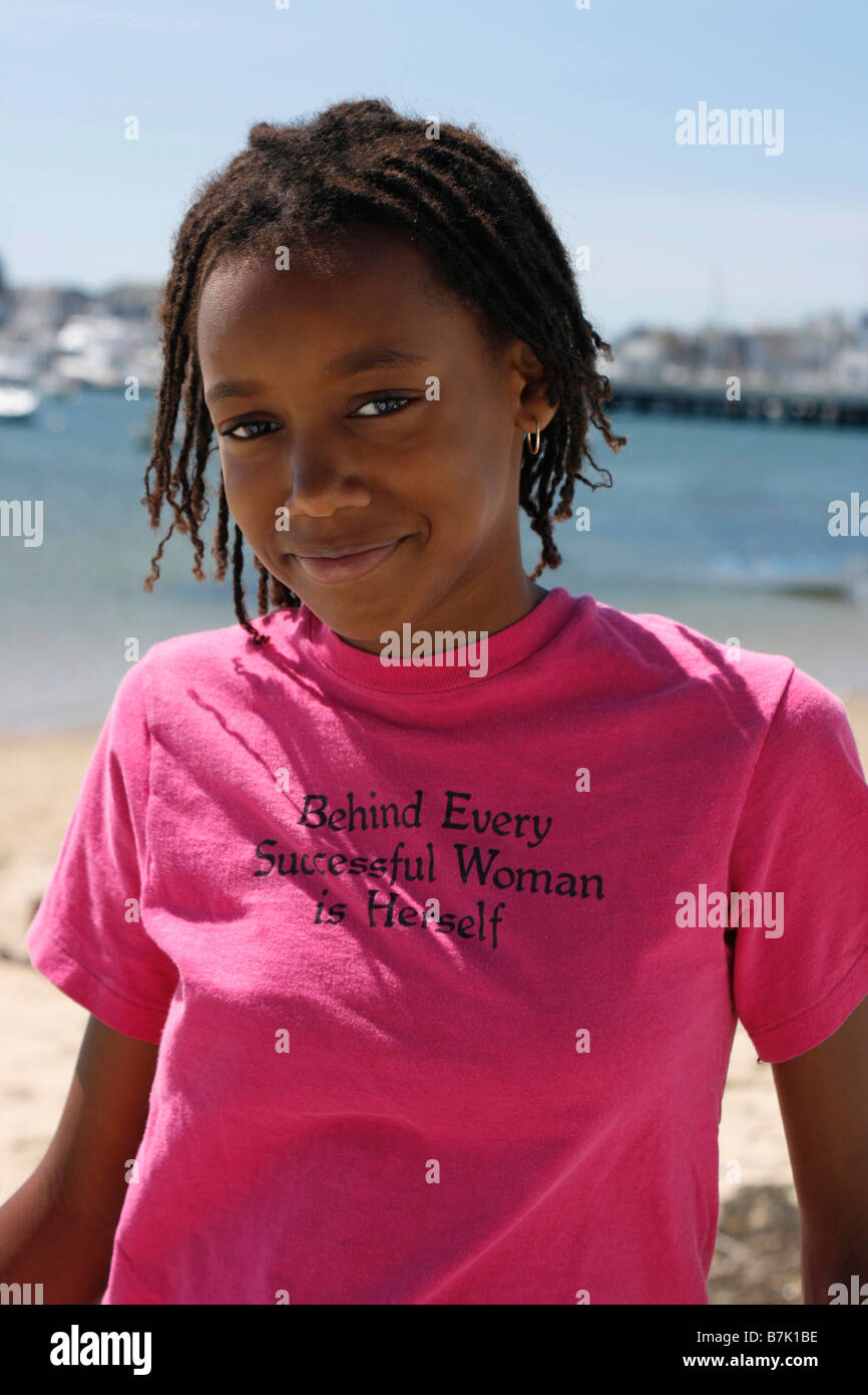 Ritratto di un felice americano nero pre teen, 11 anni, stando all'aperto dall'acqua. Foto Stock