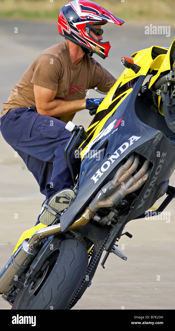 Stunt rider mono impennarsi in moto il ciclo di azione montante Foto Stock