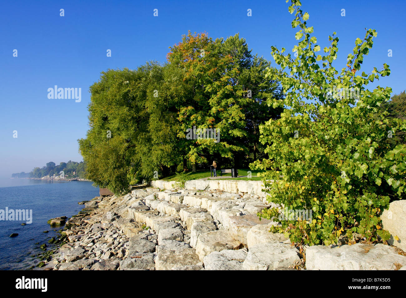 Persona a bordo di tiered rock argine lungo il Lago Ontario, Burlington Foto Stock