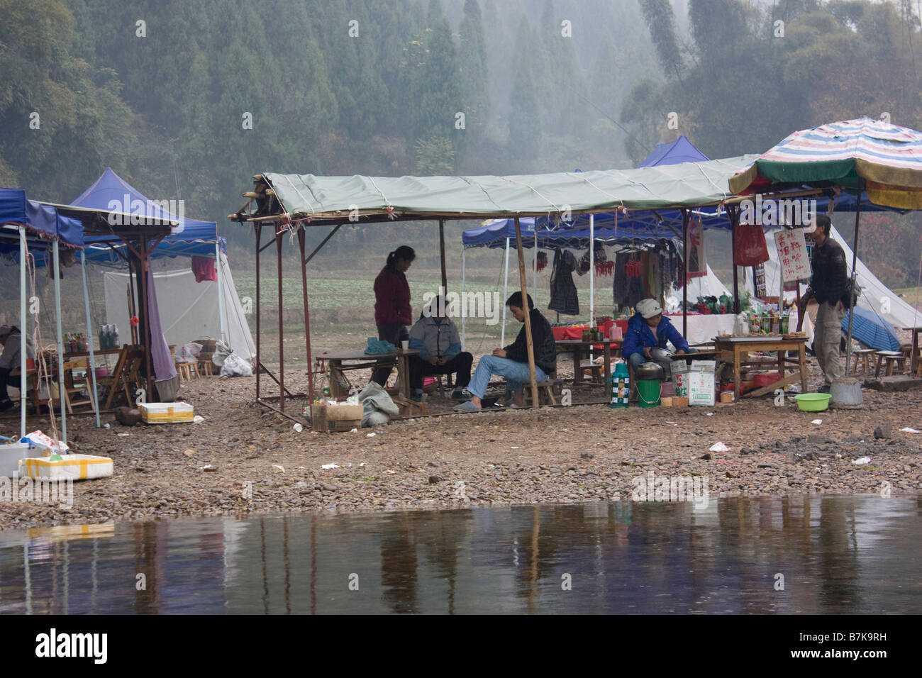 Petty commercianti mentre fate una crociera lungo il Fiume Li banca , a Xing Ping Yangshuo, Cina Foto Stock