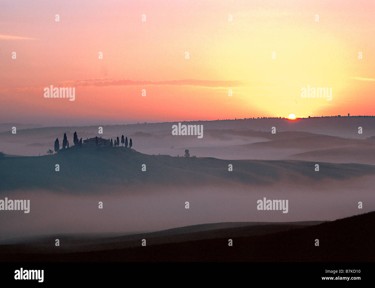 Sunrise e nebbia bassa oltre il Belvedere Agriturismo Toscana, Italia Foto Stock