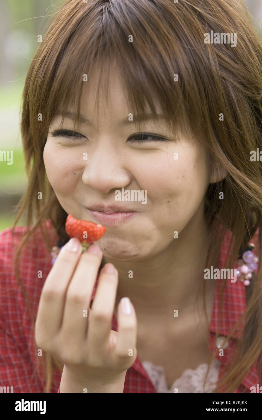 Donna di mangiare una fragola Foto Stock