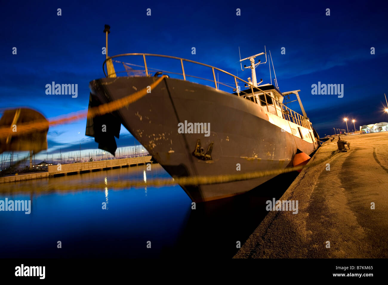 La pesca in barca ormeggiata in porto al crepuscolo Foto Stock