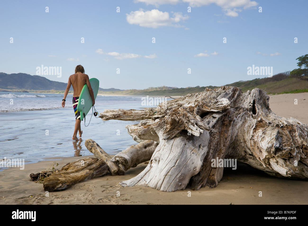 Surfer passeggiate sulla spiaggia di Playa Grande in Costa Rica. Foto Stock